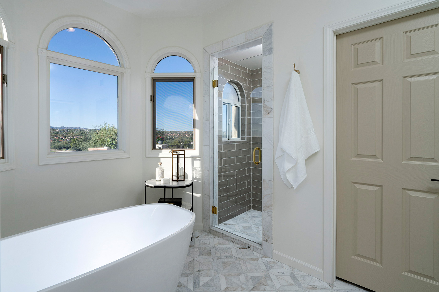 Primary bathroom renovation with marble finishes, freestanding soaking tub, custom shower, and panoramic mountain views