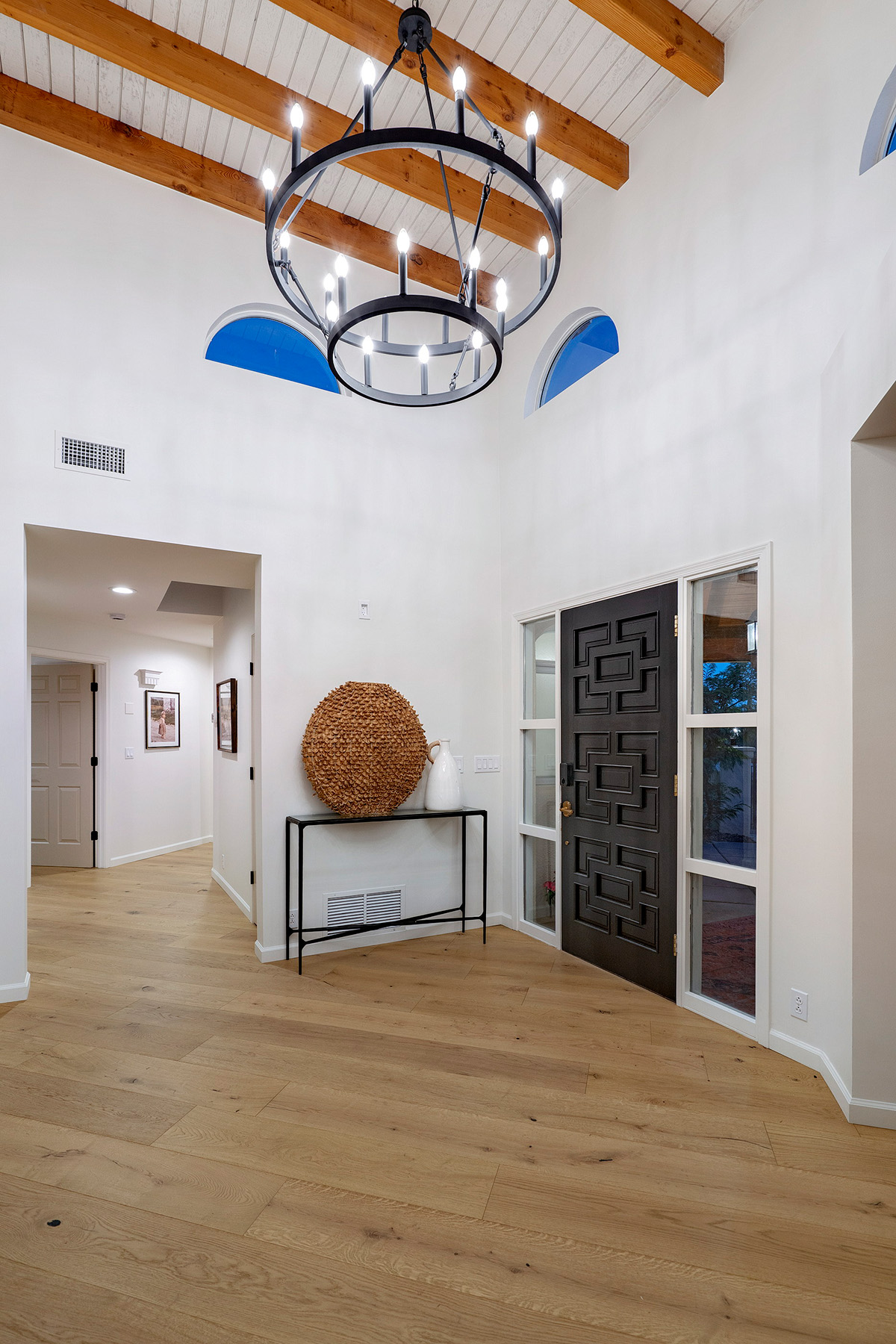Grand entryway featuring vaulted ceilings, custom front door, white oak flooring, and design-forward renovation details by Casa Garcia Morse