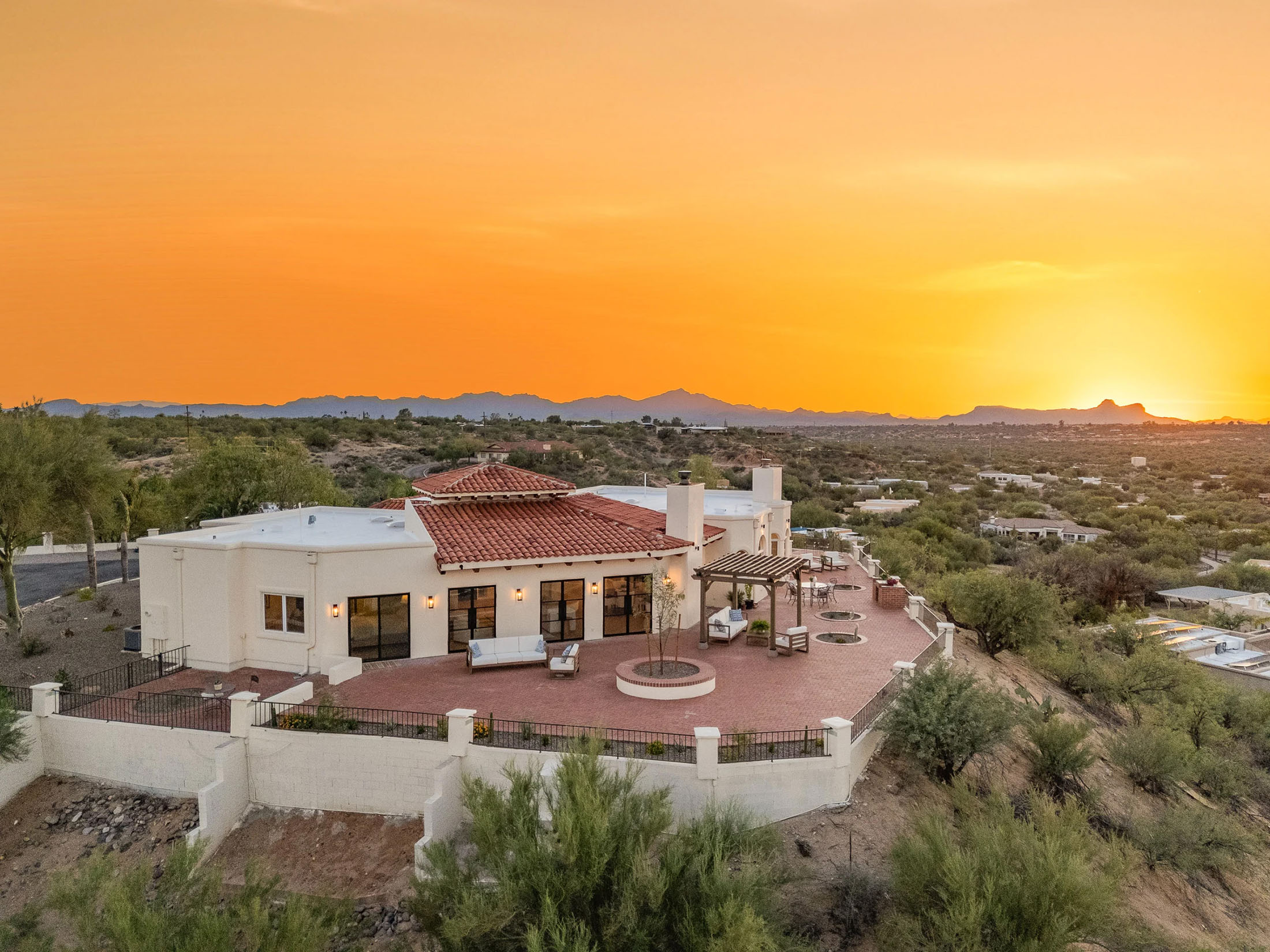 Aerial view of a fully renovated luxury home overlooking Oro Valley with expansive outdoor living spaces and mountain views