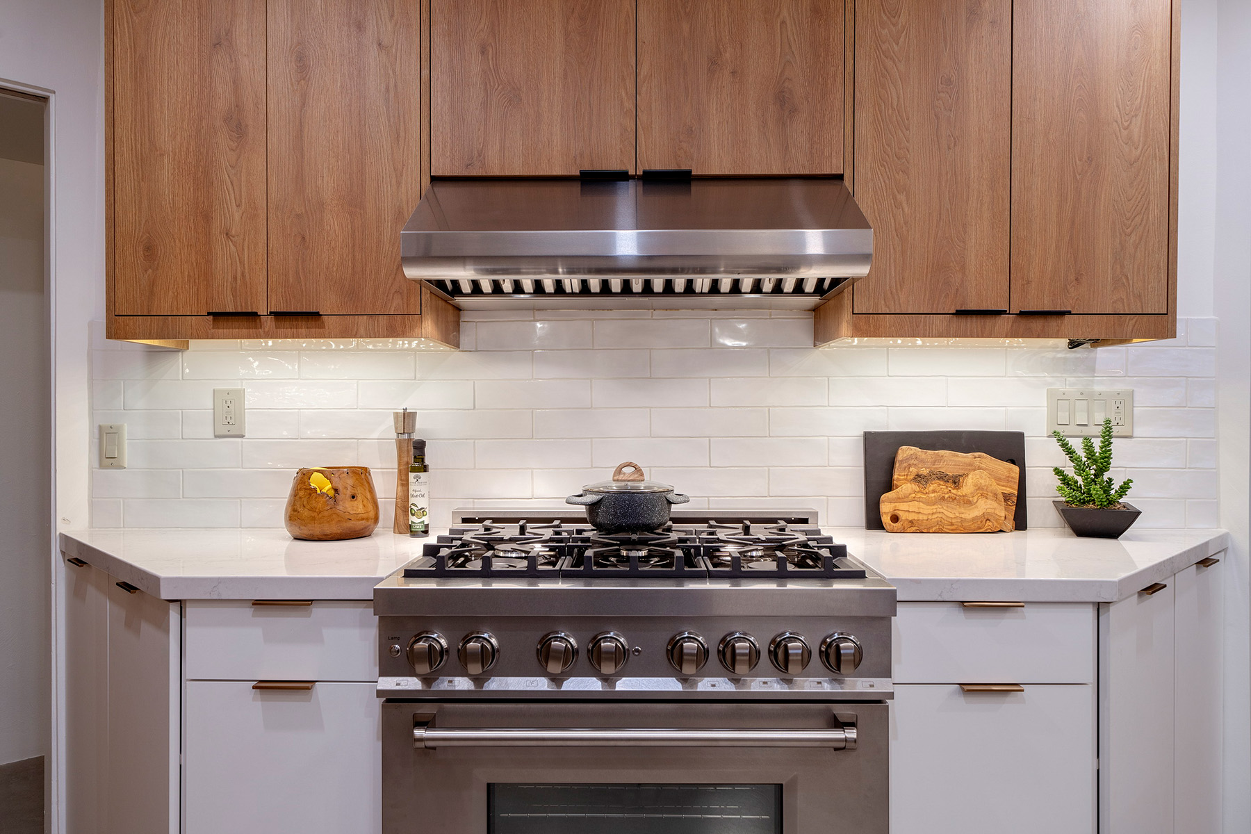 Renovated Tucson kitchen featuring custom wood cabinetry, quartz countertops, subway tile backsplash, stainless steel professional range, and luxury finishes